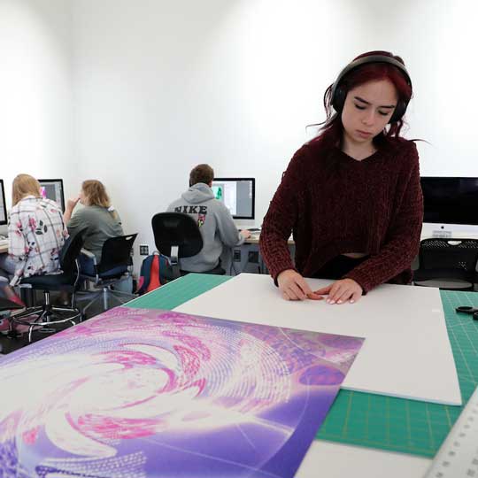 Student preparing presentation materials in digital photography studio