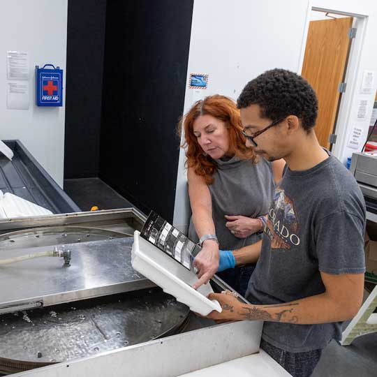 Student and professor examining test print in the analog photography studio