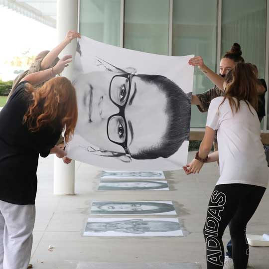 Students and professor installing art works by Sheila Preebright