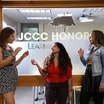 Three honors students in conversation outside the Honors Program office