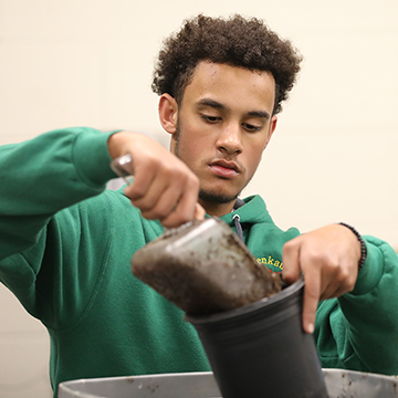 Horticulture student potting a plant