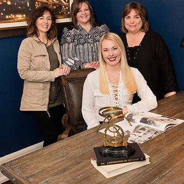 Four Interior Design Students posing at a desk