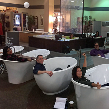 Interior design students posing in a variety of bathtub styles