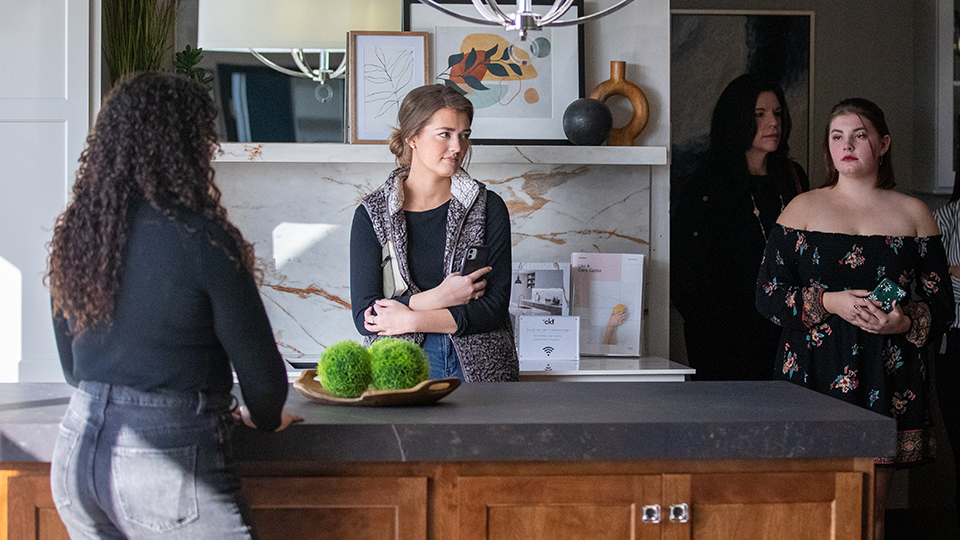 Students standing a staged kitchen area