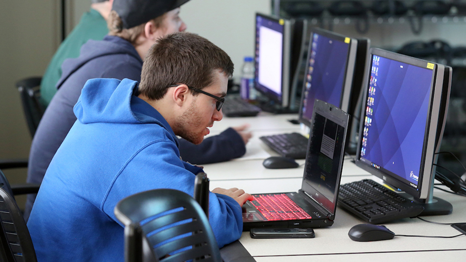 A student looks at a laptop computer