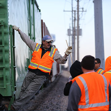 NARS students listen to an instructor in a rail yard.