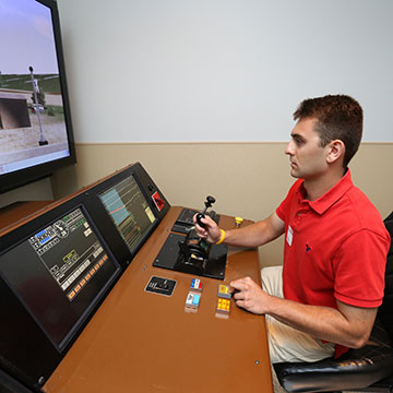 A student works in a railroad simulator.