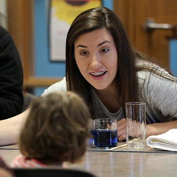 A student talks with a young child.