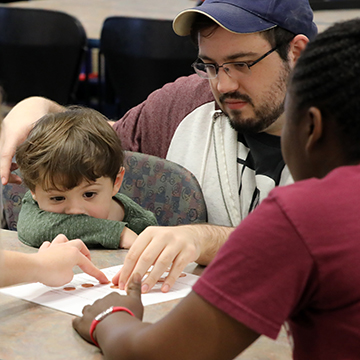 Two students work with a young boy as part of a Service Learning experience.