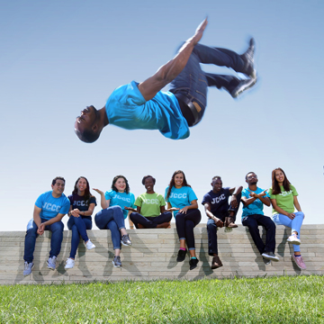 A student does a backflip while eight other students watch.