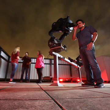 A student looks through a telescope in the JCCC observatory.