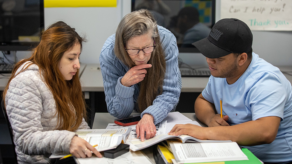 An English instructor helps two ESL students at JCCC