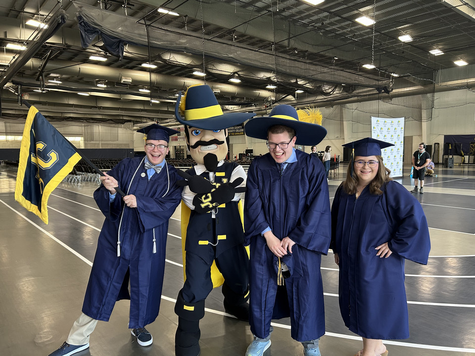 CONNECT graduates including Mark Bremmerman, left, celebrate with Jean Claude Cavalier.