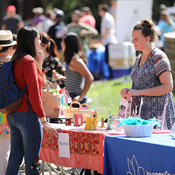 A student chats with a staff member about study abroad opportunities during the student involvement fair.