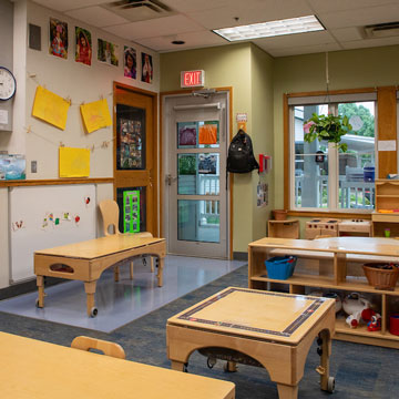Toddler Classroom, showing the two sensory tables, outdoor access, and dramatic play areas. 