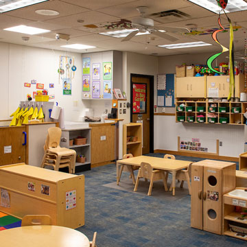 Toddler Classroom, showing the dramatic play area, music area, and child cubbies.