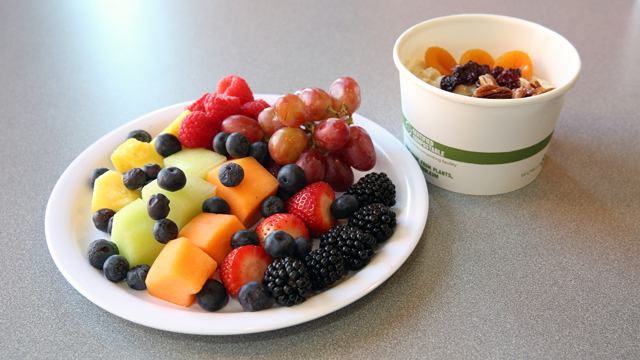 Photo of a healthy breakfast showing a plate of fruit and a cup of oatmeal