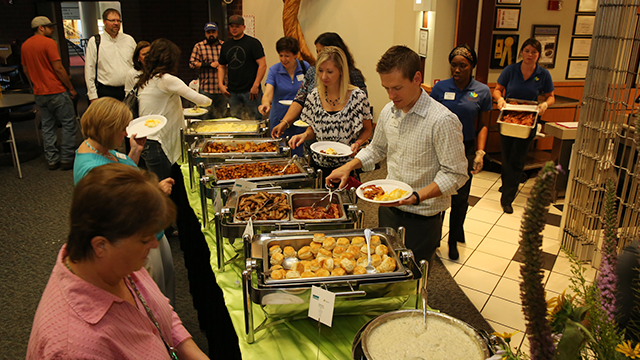 People moving through a breakfast buffet line