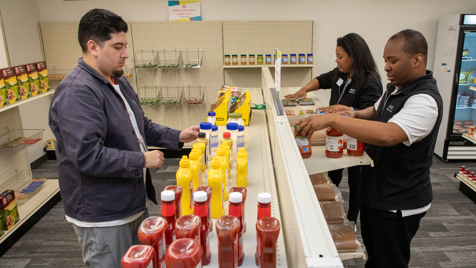 Student volunteer stocking shelves in the Basic Needs Center