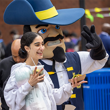 Student posing with Jean Claude, JCCC's mascot
