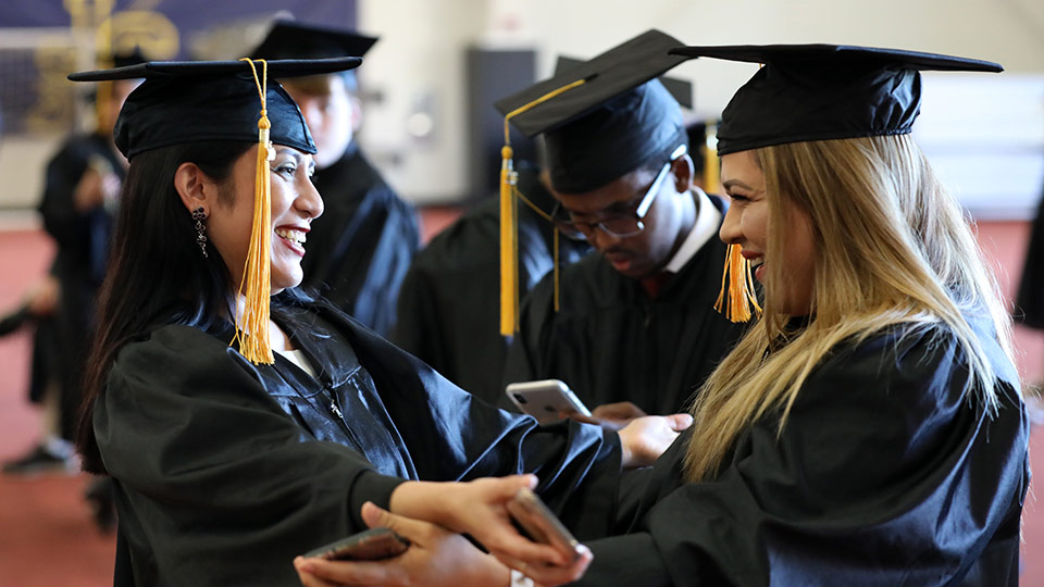 Two JCAE grads embrace each other during the graduation ceremony.