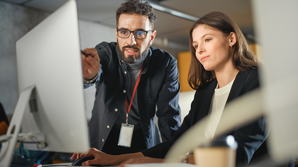 a man and a woman looking at a computer screen