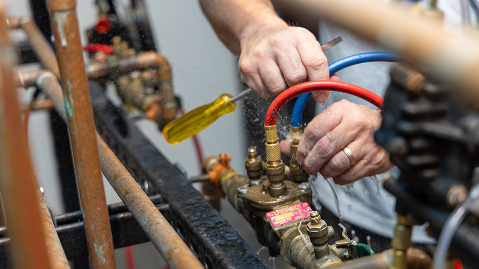 closeup of hands working on a plumbing fixture