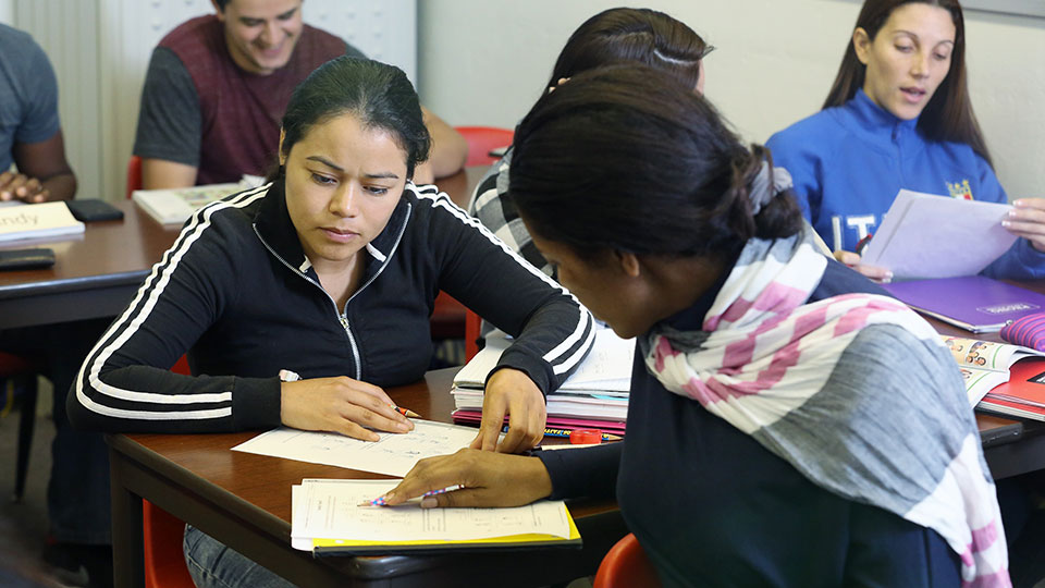 ESL students working with an instructor in a classroom