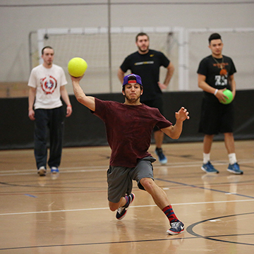 A group of men play dodge ball in the JCCC gymnasium.