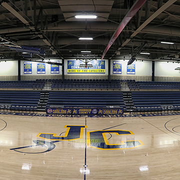 The floor of the gymnasium is decorated with the JCCC athletics logo.