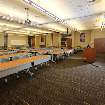 One of the meeting rooms at OHEC set with rows of tables and chairs.