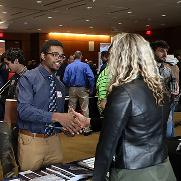 People shaking hands at an event in the Regnier Center