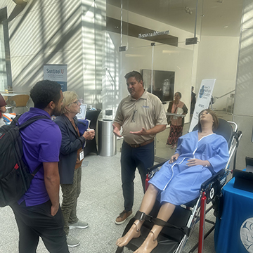 Attendees of the 2024 Healthcare Simulation conference listen to a demonstration of a medical simulation device