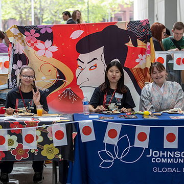 students sitting a long table decorated with Japanese flags
