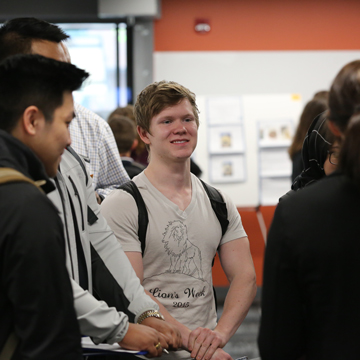 A group of students discuss experience at the Science and Math Poster Symposium.