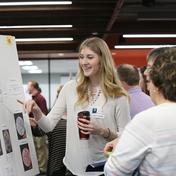 A student presents research at the Science and Math Poster Symposium.