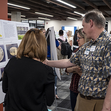 Attendees point out interesting facts on a poster.