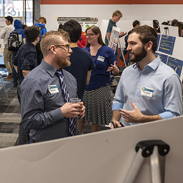 Two attendees discuss the work presented during the symposium.