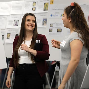 Two students discuss their work at the symposium.