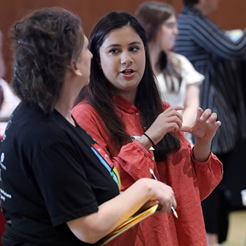 A JCCC student explains her findings to one of the organizers of the STEM Poster Symposium