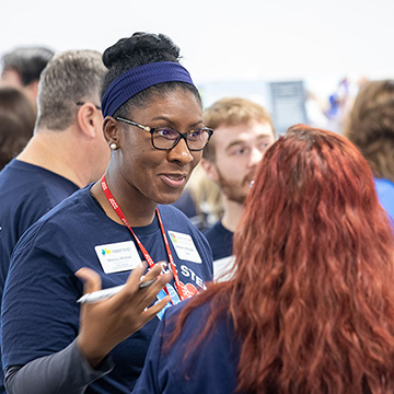 A student explains their findings to a symposium attendee