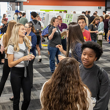 An overview shot of the 2024 JCCC STEM Poster Symposium showing the CoLab crowded with participants and posters