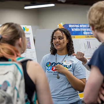 a student talks about her research at the 2025 JCCC STEM Poster Symposium