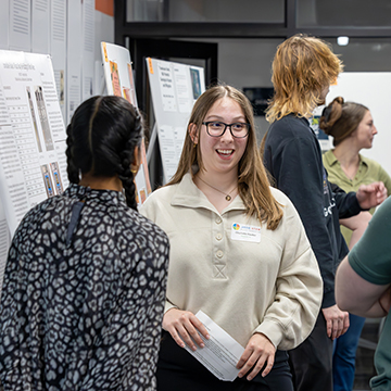 a student explains her findings at the STEM Poster Symposium