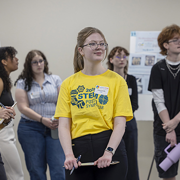 a group of students and judges wait for the symposium presentations to begin