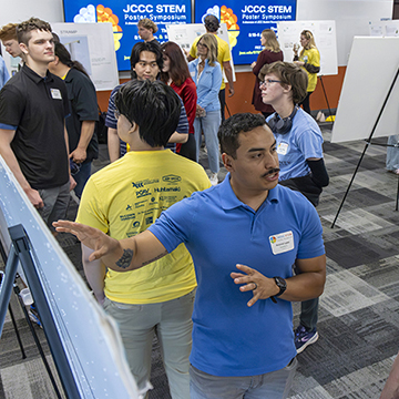 a wide angle overview shot of students presenting their research at the 2026 STEM Poster Symposium at JCCC