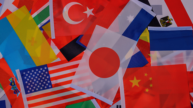 An assortment of international flags piled on a table.