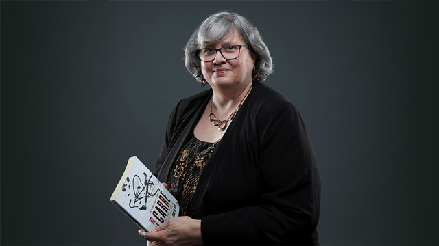 Maureen Fitzpatrick holding a copy of the book "The Spy Who Came in from the Cold"