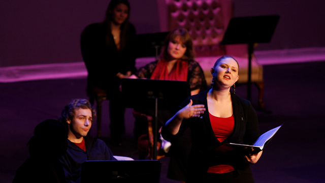 A woman singing in an audition setting.