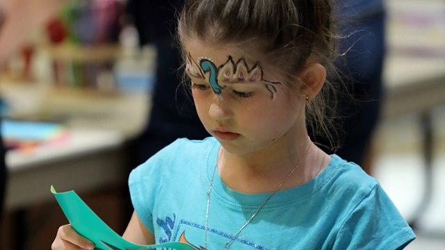 a girl holding an art project.